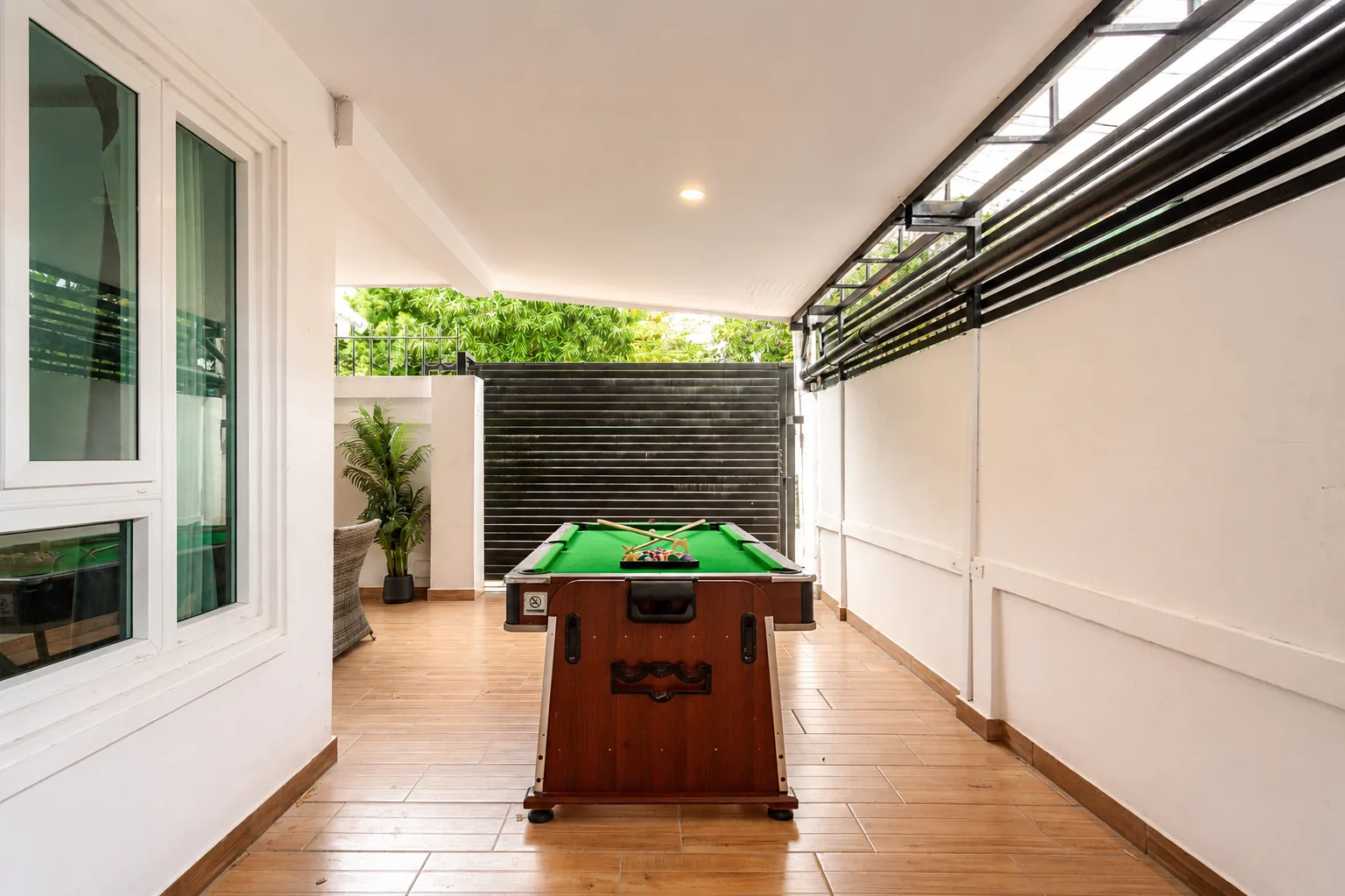 Covered terrace beside the pool with a full-size pool table